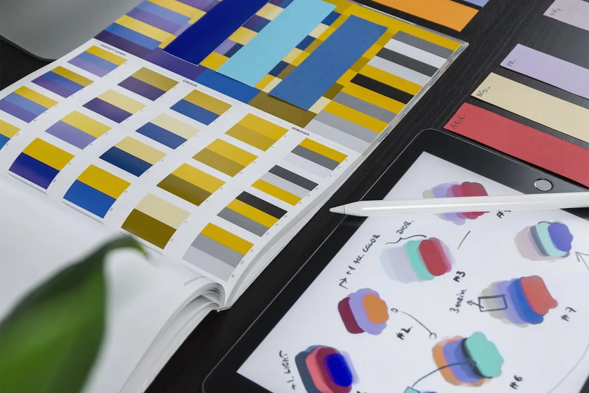 Catálogo de cores aberto sobre a mesa de um designer de marca